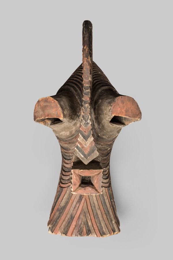 This wooden kifwebe, or mask, has a face that is boldly simplified with a high protruding forehead, close-set eyes under hooded eyelids, and is completely covered by a dense network of painted parallel grooves.
