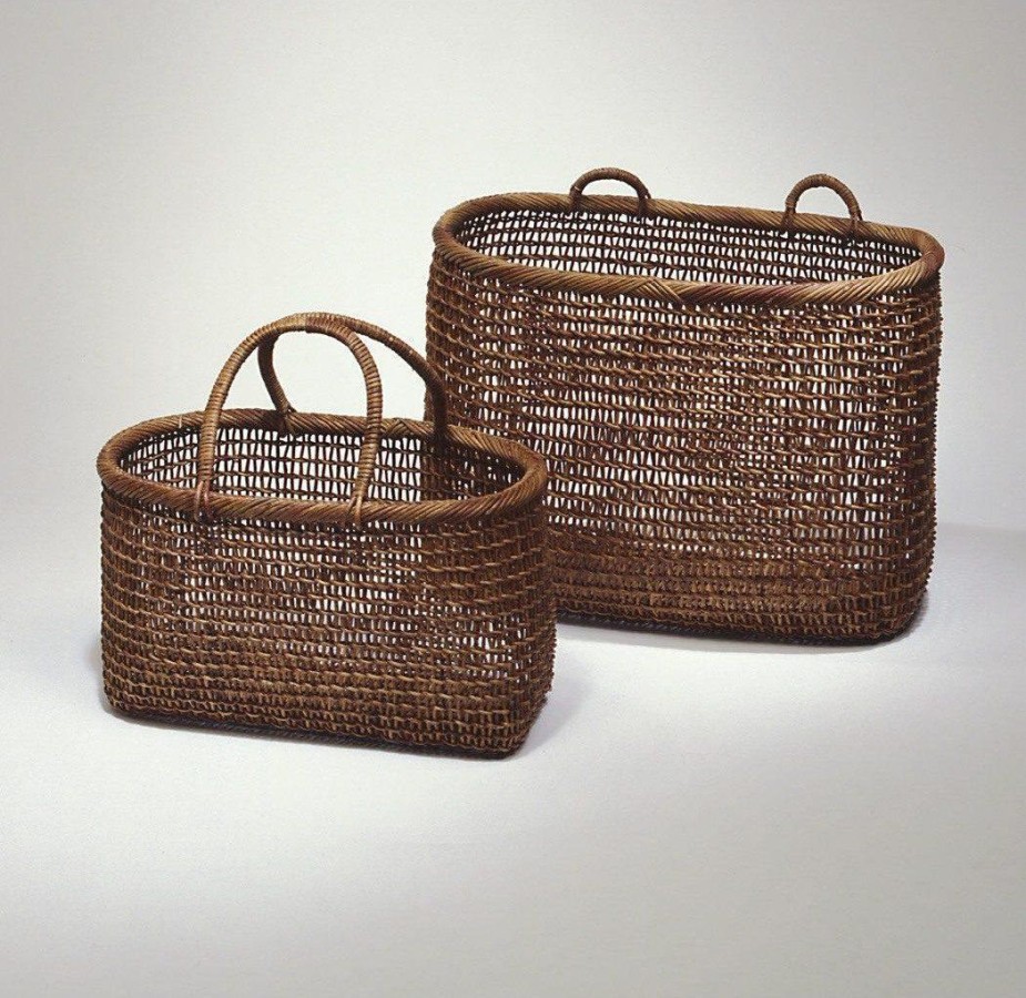 These woven baskets are oval shaped and made from akebi vine. The akebi vine is a dark brown color. The weaving is loose enough to see through, but tight enough to hold items.