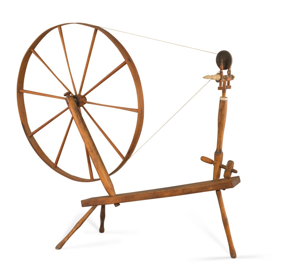 This spinning wheel was made by Shakers, a communal and celibate Protestant community known for their spare, functional, and elegant forms. This spinning wheel is no exception. The large spinning wheel rests on a thin undecorated bench with three legs.