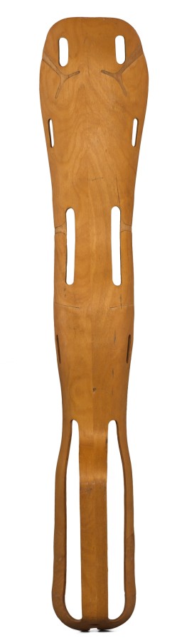 This “plyformed wood” leg splint was designed as a valuable contribution to World War II by Charles and Ray Eames. It was made from one piece of wood bonded by resin glue and shaped by heat and pressure. This splint was designed to fit the shape of the user's buttocks, thigh, calf, and heel.